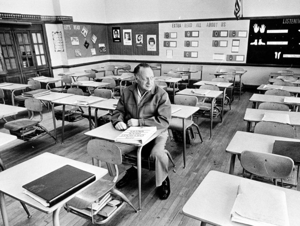 Victor Herman sitting in an empty classroom