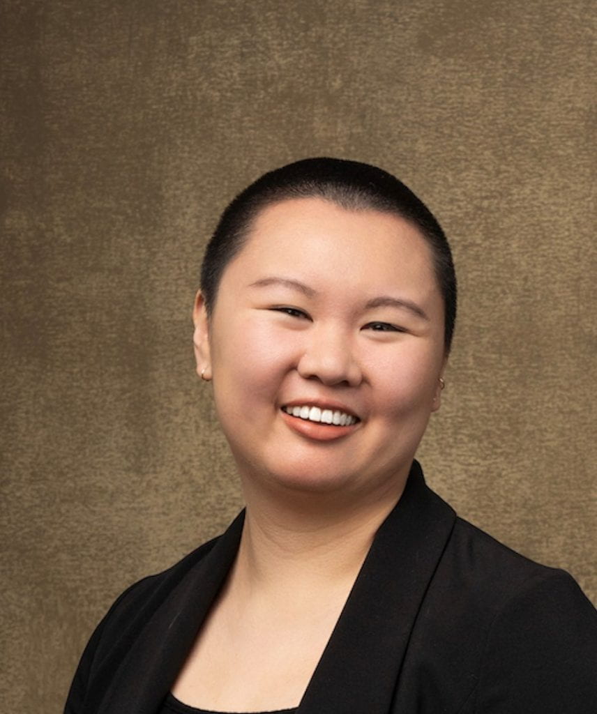 Headshot of Lily Chen. She has very short black hair and is wearing a black blazer.